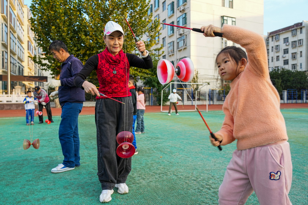 10月22日，志愿者在淄博市博山區中心路小學為學生們傳授抖空竹。
