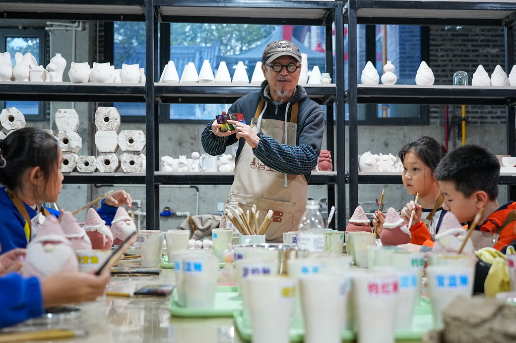 10月22日，志愿者趙錦星為淄博市博山區中心路小學學生講解陶瓷制作技藝。