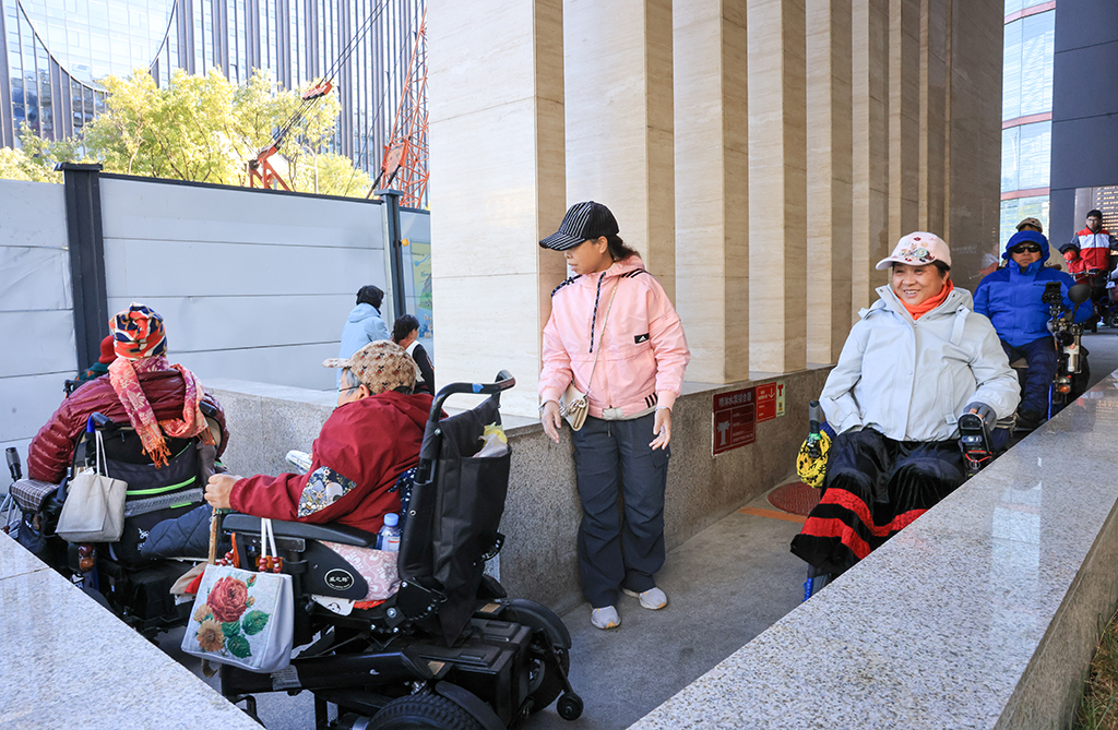 10月26日，志愿者在幫助肢體殘疾人士觀影后離開。