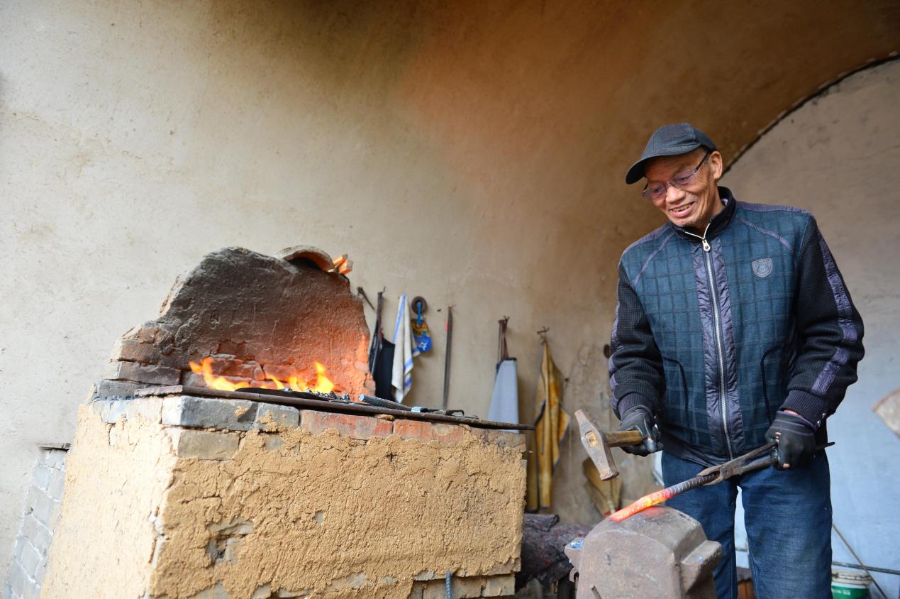晉城市澤州縣大陽古鎮，當地自古冶鐵業發達，村民向游客展示傳統冶鐵技術。陳斌攝