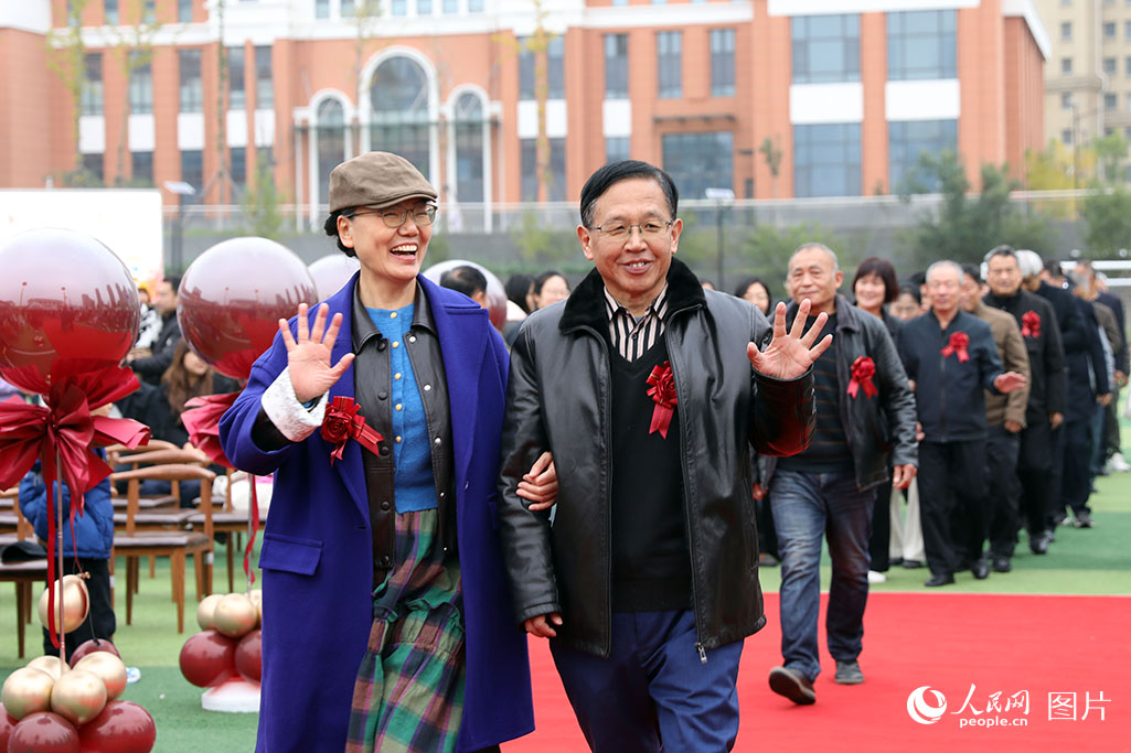 10月26日上午，山東省濟南市高新區金谷小學操場，99對金婚老人在學生志愿者的引導與祝福下，攜手踏上紅毯，重現數十年前的美好瞬間。人民網記者 劉祺攝