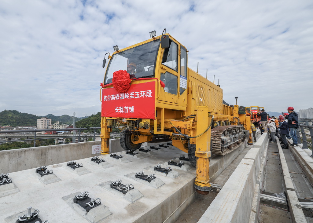 11月5日，在浙江省臺州市杭臺高鐵溫嶺至玉環段施工作業現場，中鐵十四局工作人員操作長軌牽引車將首段500米長鋼軌精準鋪設在無砟道床上。