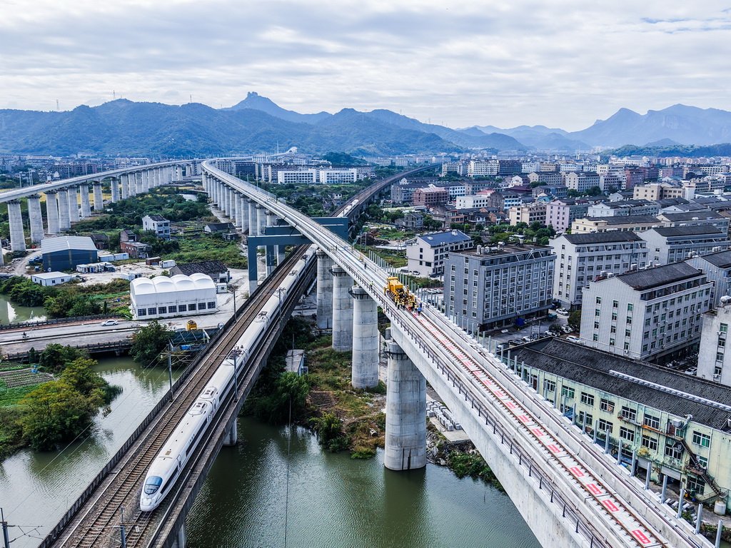 11月5日，在浙江省臺州市杭臺高鐵溫嶺至玉環段施工作業現場，中鐵十四局工作人員操作長軌牽引車進行鋪軌作業（無人機照片）。
