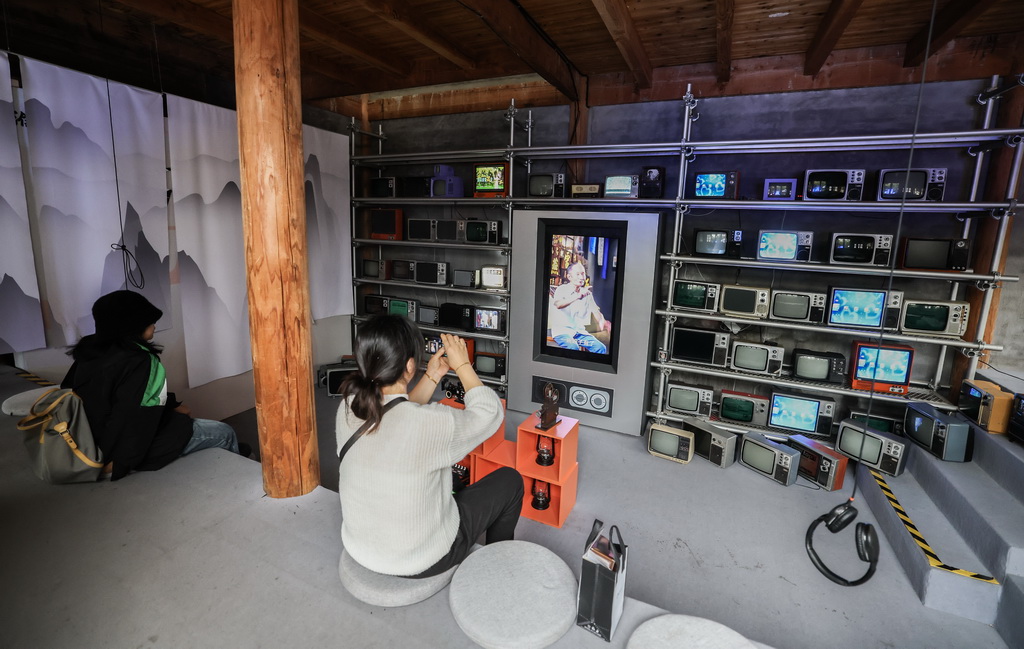 11月5日，游客在濮院時尚古鎮的互聯網生活嘉年華觀看老舊電視機播放的濮院傳統生活場景。