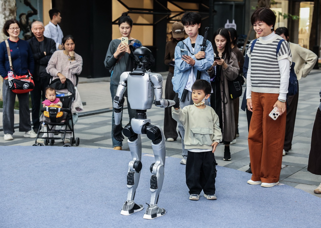 11月5日，游客在濮院時尚古鎮與人形機器人互動。