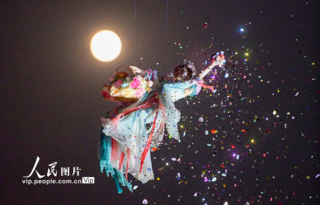 2025年11月5日，在河南省洛陽市洛邑古城景區，演員表演的“仙女散花”與“超級月亮”構成一幅美麗的畫卷。張怡熙攝（人民圖片網）