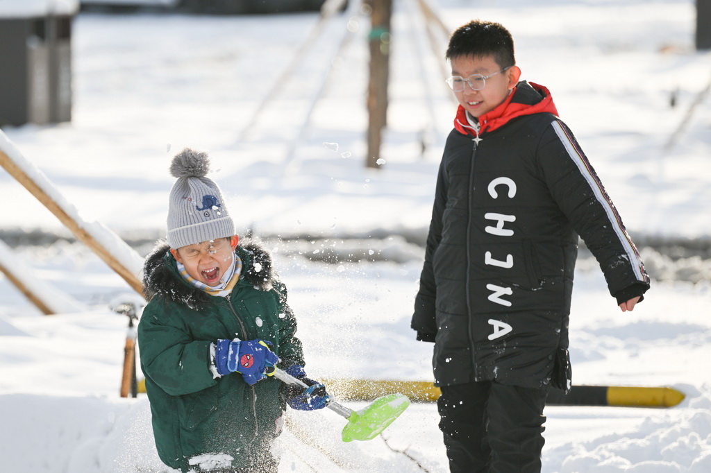 11月6日，兩名男孩在烏魯木齊市水磨溝區的一處公園里玩雪。新華社記者 辛悅衛 攝