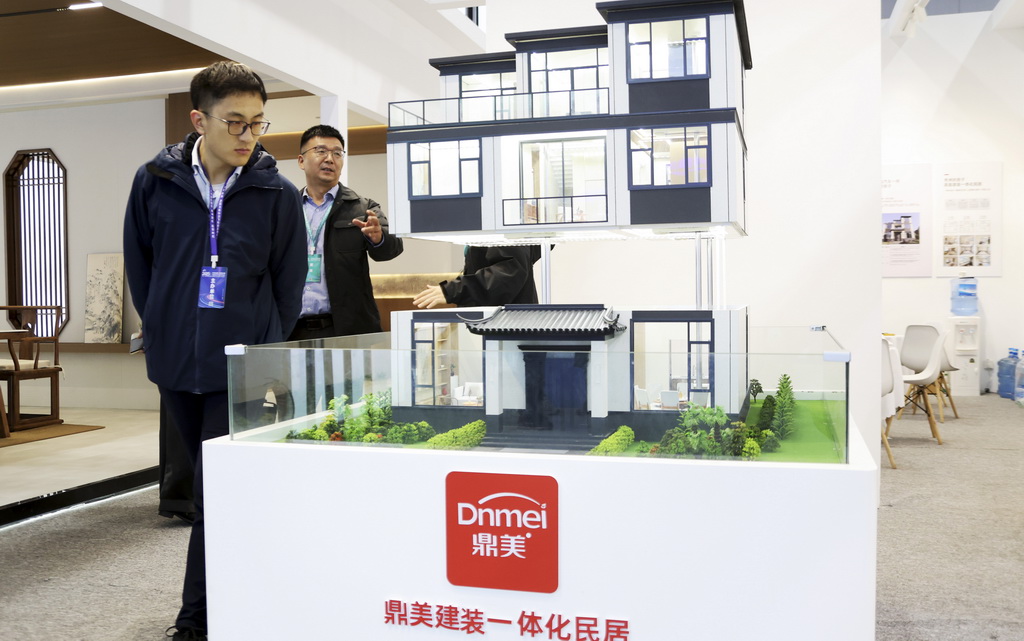 11月6日，參觀者在住博會上觀看展出的一體化民居模型。