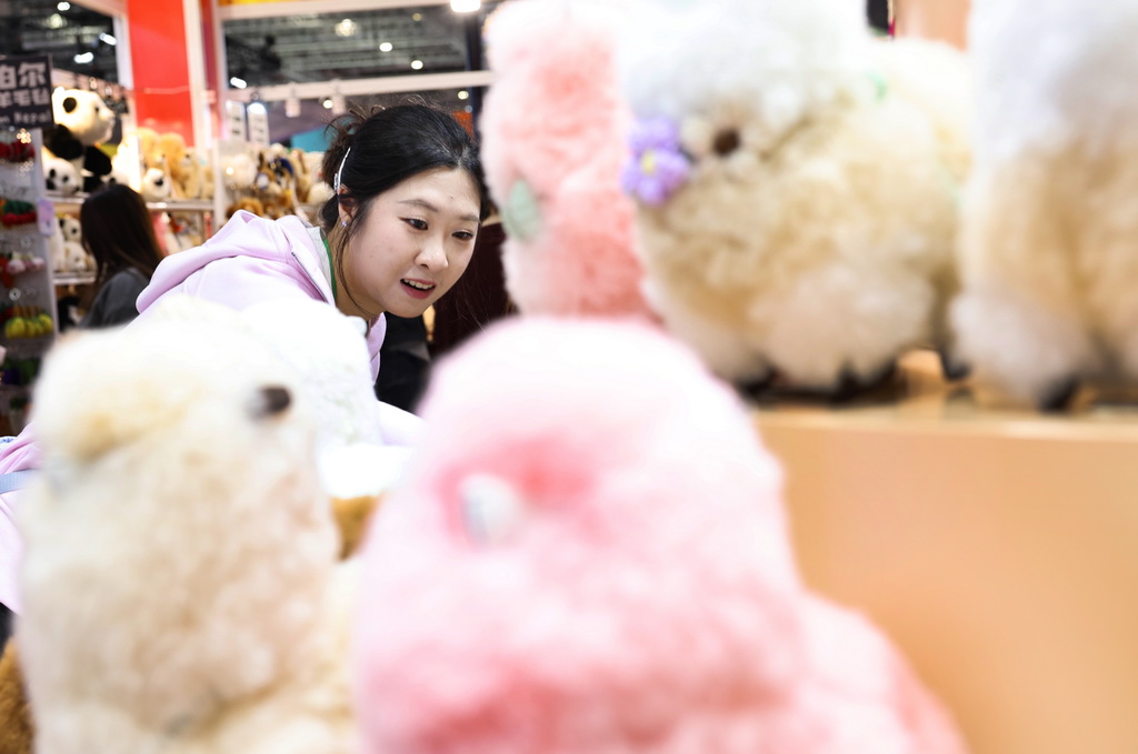 11月8日，在第八屆進博會消費品展區，參觀者在秘魯溫暖駝品牌的羊駝毛制品前駐足觀看。新華社記者 方喆 攝