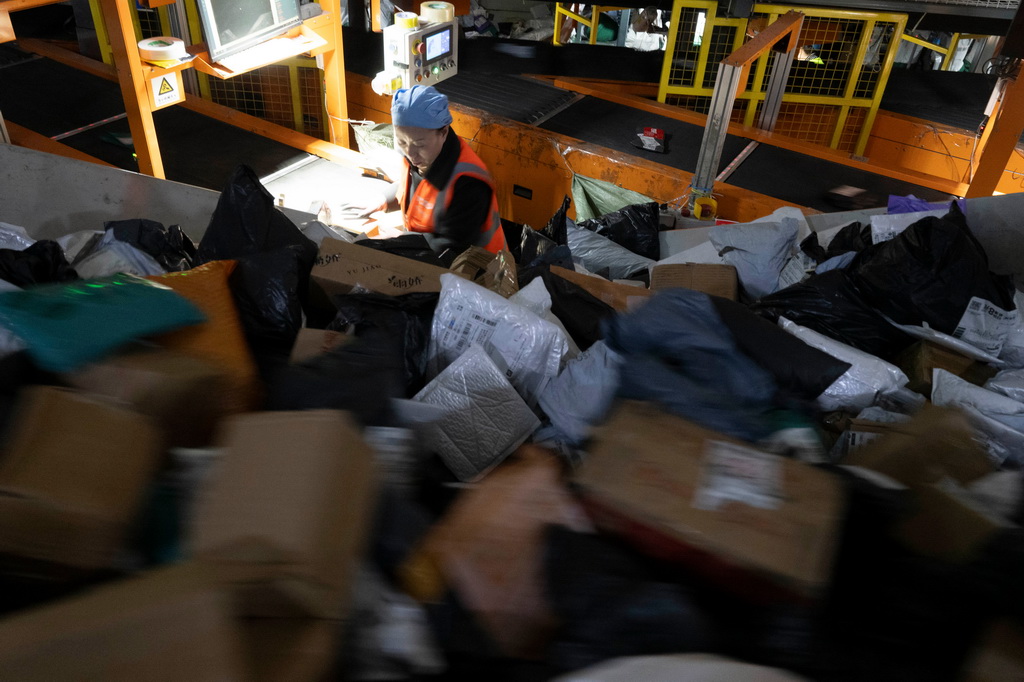 11月10日晚，在中國郵政集團有限公司黑龍江省哈爾濱郵區中心，工作人員在分揀快遞。