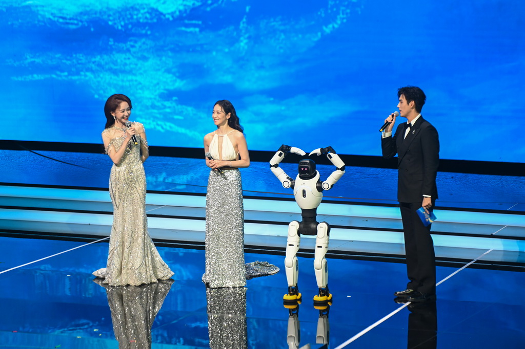 11月11日晚，主持人在2025年中國金雞百花電影節開幕式現場與機器人互動。