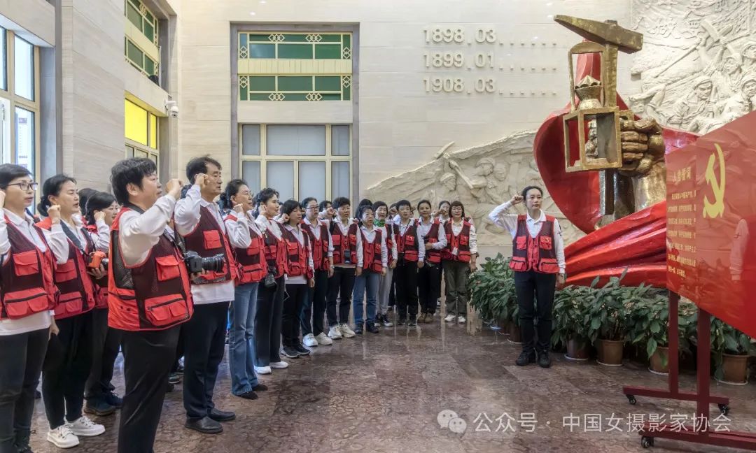 中國女攝影家協會組織采風團成員在安源路礦工人運動紀念館重溫入黨誓詞。