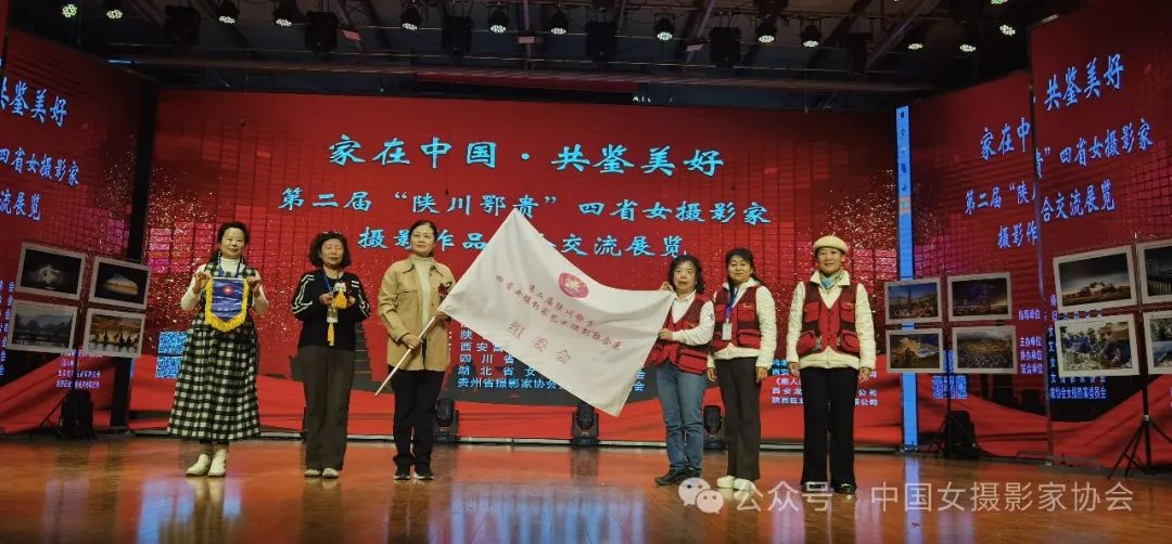 陜西省女攝影家協會主席山新莉向下一屆承辦單位——貴州省攝影家協會女攝影家委員會主任鄭璐遞交會旗。