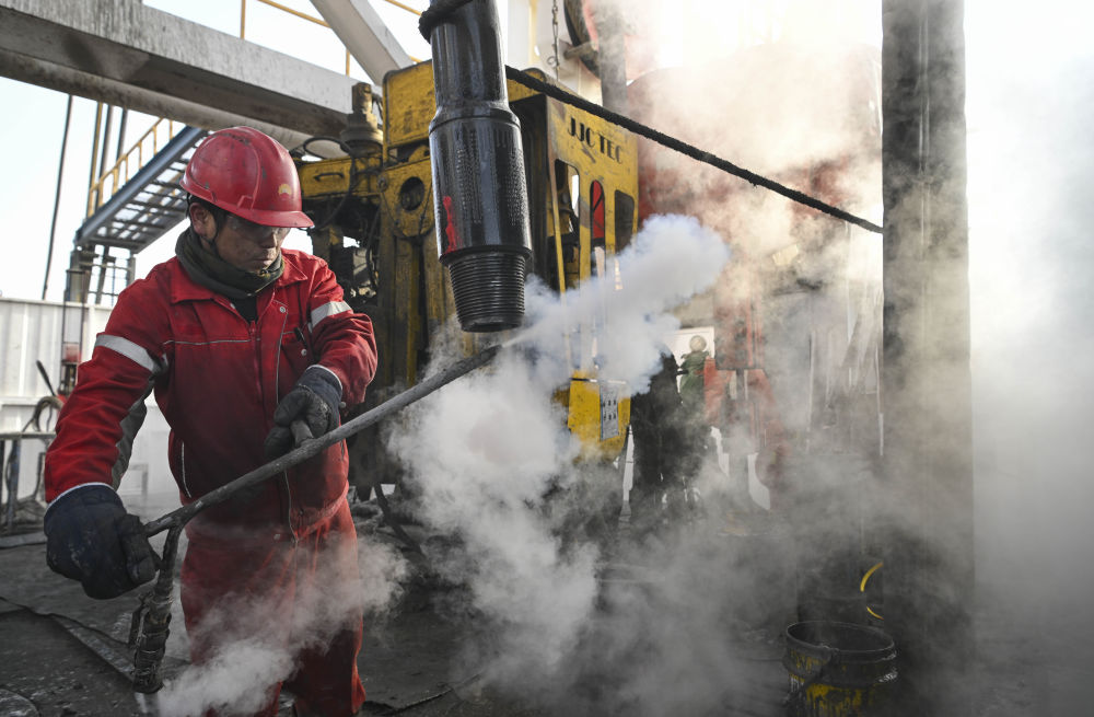 2025年2月19日，工人在中國石油塔里木油田深地塔科1井上清洗鉆桿螺紋。新華社記者 胡虎虎 攝