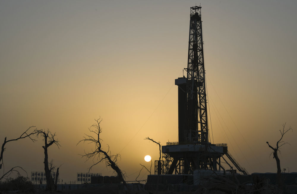 這是2025年2月18日在新疆塔克拉瑪干沙漠腹地拍攝的中國石油塔里木油田深地塔科1井及周邊胡楊樹。新華社記者 胡虎虎 攝