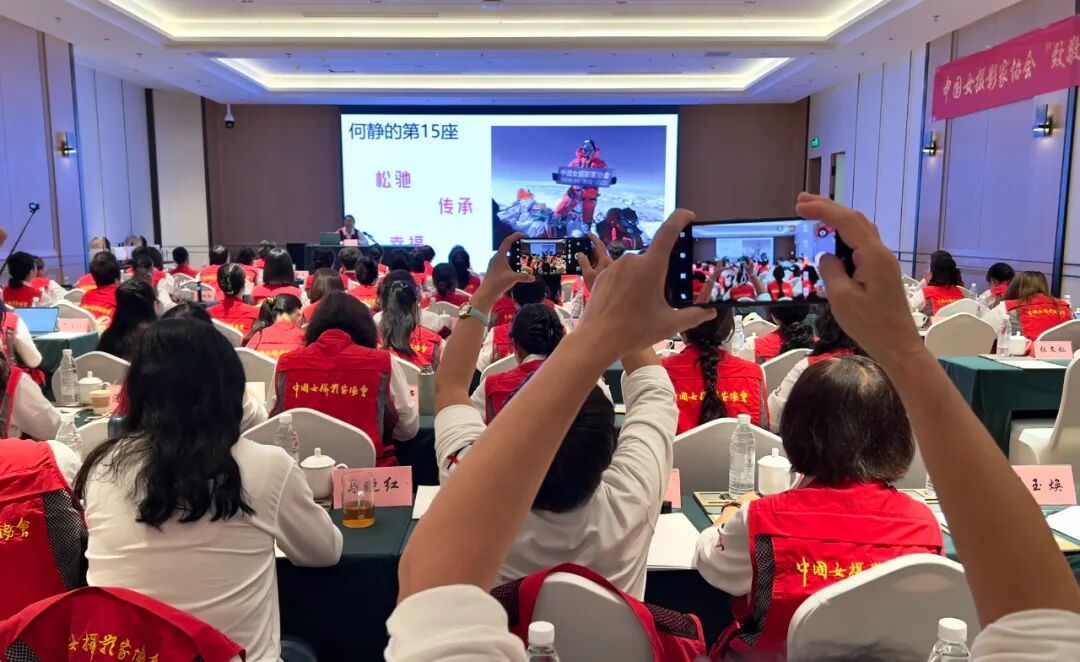 何靜分享登頂珠穆朗瑪峰時展示中國女攝影家協會橫幅。靳雪莉 攝